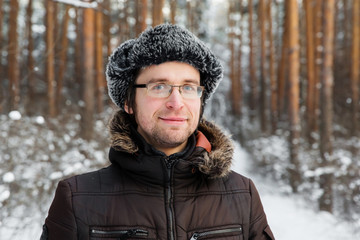 Man in fur winter hat with ear flaps smiling portrait