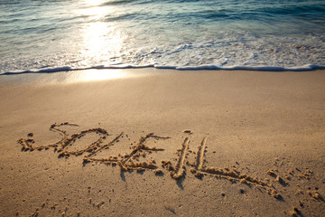 mot soleil écrit en français sur le sable sur la plage