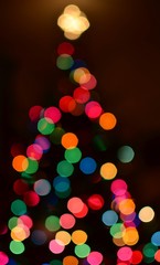 Colorful bokeh background in the shape of a Christmas tree