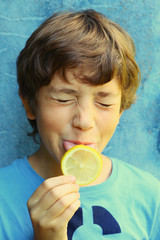 boy eating sore lemon grimacing