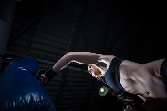 Female Athlete boxer punching a punching bag in a gym