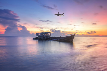 Obraz premium Wreck fishing boat next to the beach, Thailand U-Tapao Airport. Wrecked boat abandoned stand on beach or Shipwrecked off the coast of Thailand.