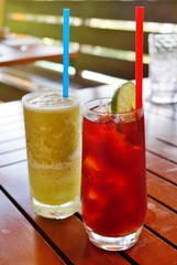 Drinking a green smoothie and an iced tea outdoors in summer