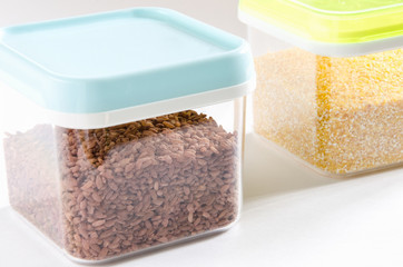 Food storage. Food ingredients (polenta and brown rice) in plastic containers. Selective focus.