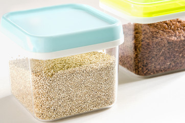 Food storage. Food ingredients (quinoa and brown rice) in plastic containers. Selective focus.