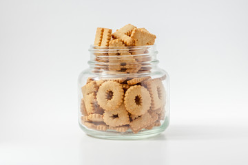 Alphabet shaped biscuits in bottle with white background.