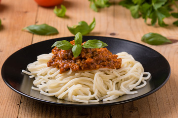 spaghetti bolognese on black plate