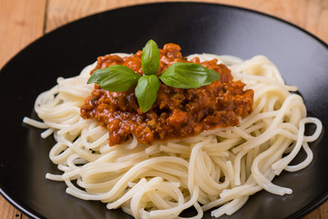spaghetti bolognese on black plate