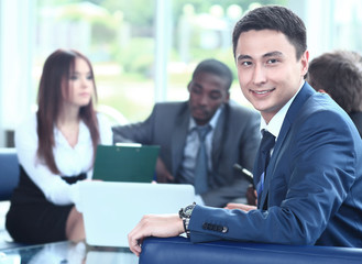 Obraz premium Confident young business man attending a meeting with his colleagues