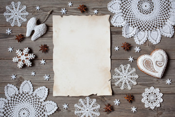 Christmas wooden background with  lace snowflakes and blank greeting list