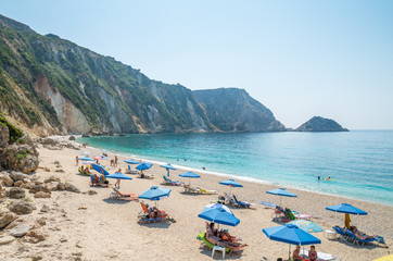 Fototapeta na wymiar KEFALONIA ISLAND, GREECE - August 8, 2015: People relaxing at the beach of Petani, Kefalonia island, Greece.
