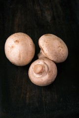 Few champignons on old wooden board