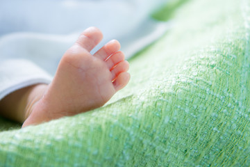 Naklejka premium child baby foot, foot of children lying on the bed...