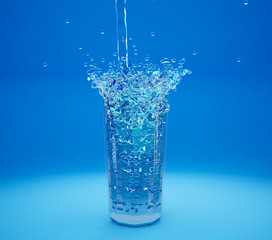 Splash cold water in a glass, blue background, 3D illustration,
