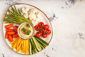 Healthy homemade hummus with assorted fresh vegetables.