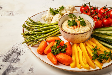 Healthy homemade hummus with assorted fresh vegetables.