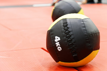 Medicine balls on red mats in the athletic gym. Exercise balls for rehabilitation and strength training.