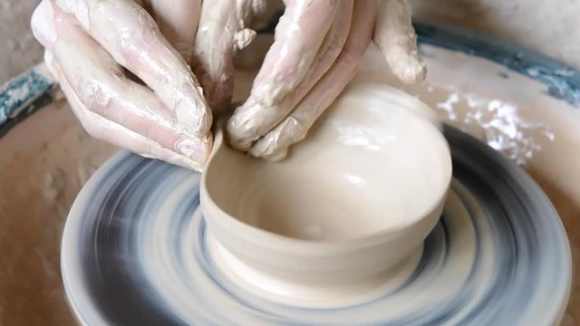 Woman girl her hands dub wall jug, sculpts out of clay on circle.Workshop on sculpt white clay closeup.Dirty hands in the clay.Making ceramic products Macro. Artistic creative. Camera motion HD1080.