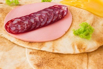 Smoked meat on wheat tortilla. Closeup