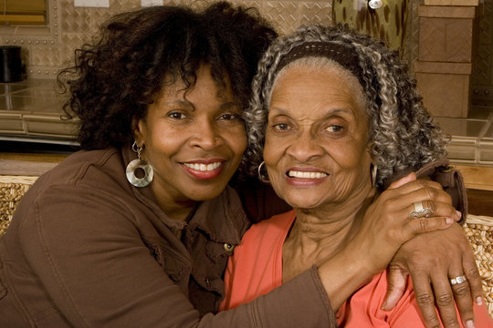 Portrait of a senior woman hugging her daughter.