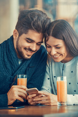 Happy young couple having fun in cafe