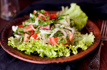 Тарелка с салатом из свежих овощей на деревянном столе, рустик