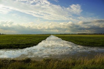 Beautiful river receding into the distance with reflection of clouds
