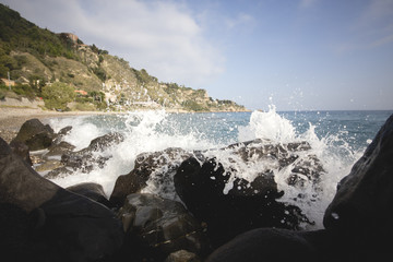 Deep blue sea waves splashing volcanic rocks, Sicily coast