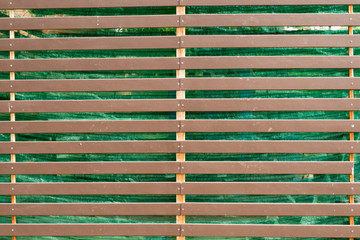 Brown steel fence in front of the green screen