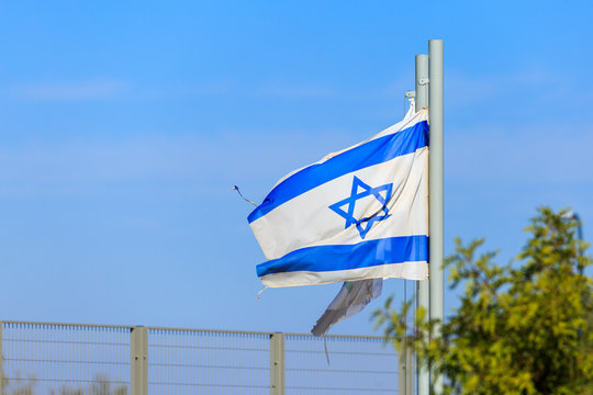 Blue and white flag of Israel on strong wind