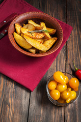 bowl of roasted potatoes with rosemary and tomatoes