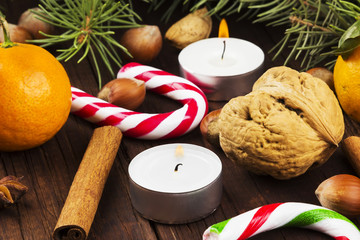 Christmas jewelry - candles, fir-tree branches, nuts, cinnamon,