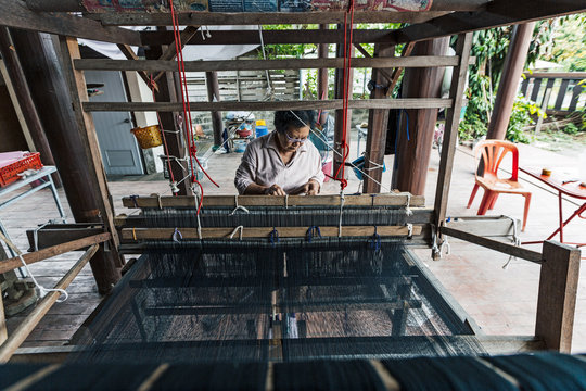 Tai Lue (Lu) indigenous weaver at a wooden loom weaving Tai Lue traditional clothing, Chiang Mai