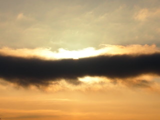 Fototapeta na wymiar Необычное темное облако в зимнем небе освещено солнцем
