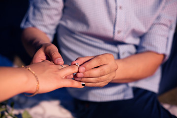 Close Up Of Male Hand Inserting An Engagement Ring Into A Finger