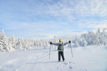 Fototapeta na wymiar Happy young man standing with raised hands enjoying amazing winter landscape. Russia, Ural