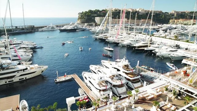 World Fair MYS Monaco Yacht Show, Port Hercules, luxury megayachts, many shuttles, taxi boat, presentations, Journalists, boat traffic, Azur water, aerial view, mountains on background, perspective
