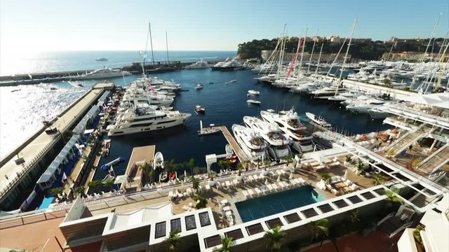 World Fair MYS Monaco Yacht Show, Port Hercules, luxury megayachts, many shuttles, taxi boat, presentations, Journalists, boat traffic, Azur water, aerial view, mountains on background, perspective