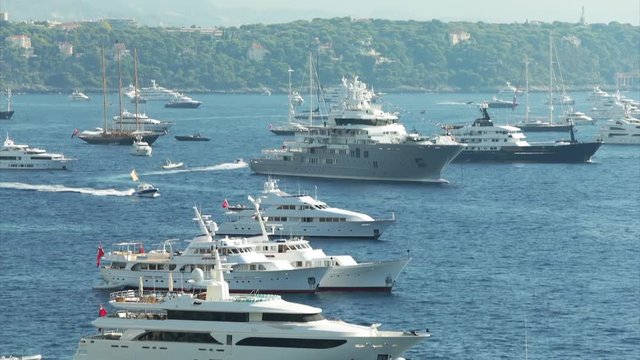 World Fair MYS Monaco Yacht Show, Port Hercules, luxury megayachts, many shuttles, taxi boat, presentations, Journalists, boat traffic, Azur water, aerial view, mountains on background, perspective