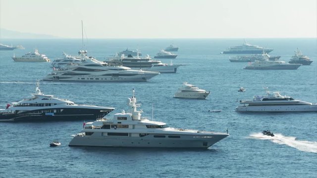 World Fair MYS Monaco Yacht Show, Port Hercules, luxury megayachts, many shuttles, taxi boat, presentations, Journalists, boat traffic, Azur water, aerial view, mountains on background, perspective