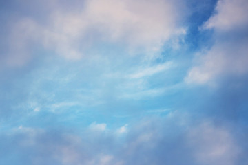 white clouds against the blue sky on a sunny winter day in the evening.