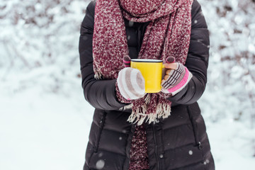 Femme tenant une tasse jaune de chocolat chaud à l& 39 extérieur