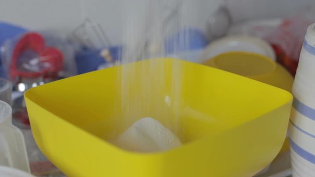 Pastry sifts the flour through a sieve into a bowl of yellow