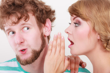 Woman telling an astonished man some secrets