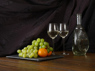 Still life: white wine and fruits.