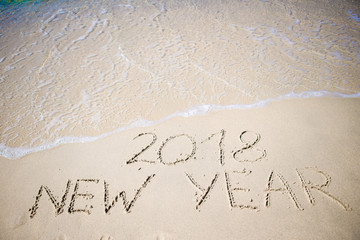 2018 New Year written in the white sand