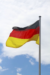 wehende Deutschlandfahne am wolkigen Himmel