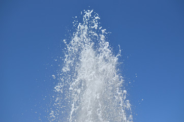 Obraz na płótnie Canvas Top of foamy fountain water on clear blue sky