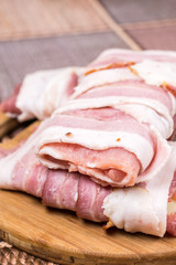 Closeup macro view stuffed meat with yellow cheese in bacon