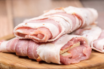 Closeup macro view stuffed meat with yellow cheese in bacon